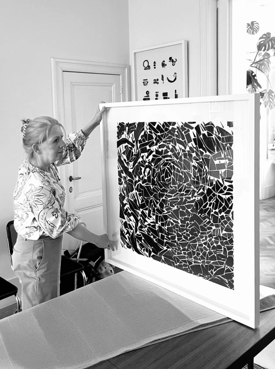 Afbeelding van Karine De Dycker die één van haar kunstwerken vasthoudt.